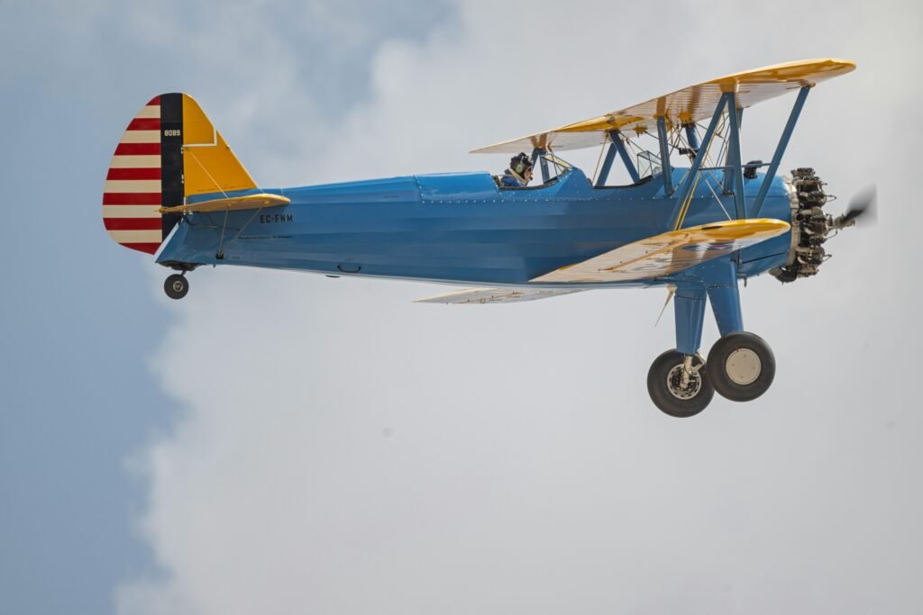 A vintage blue biplane performing aerobatics in the sunny skies of Madrid. Captured in stunning detail.